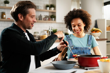 Loving couple eating lunch together at home. Husband and wife enjoying in tasty meal.