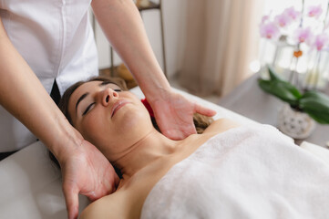 Caucasian woman lying on spa bed receiving relaxing shoulder massages