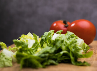 Fresh salad and tomatoes on a wooden board - studio photography