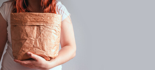 Food delivery service. Woman holding take away paper bag with fresh grocery food from delivery over...