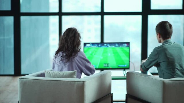 happy couple playing video game with controller on play station at home