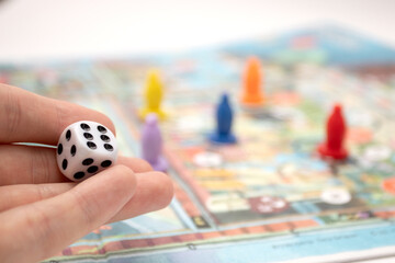 Hand throwing the dice on the board game playing field