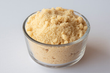 Brown sugar in a bowl on white background