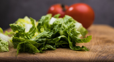Fresh salad and tomatoes on a wooden board - studio photography