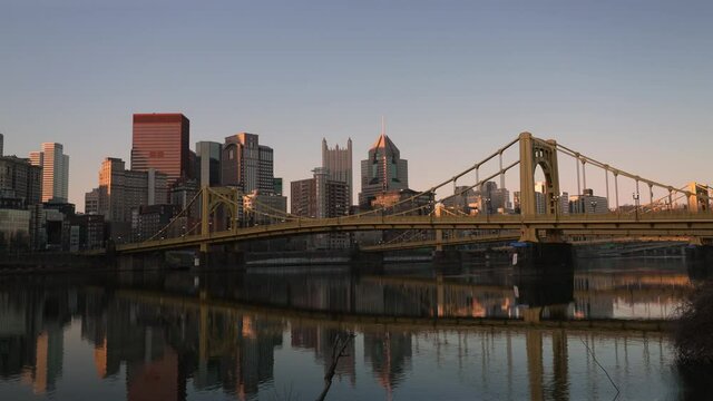 An early morning sunrise time lapse establishing shot of the Pittsburgh, Pennsylvania skyline. The Allegheny River in the foreground.  	