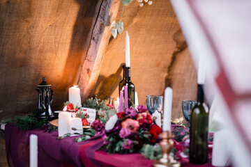 Delicate wedding white cake decorated with pomegranate and succulent surrounded by flowers and candles.