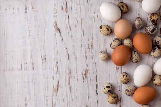 Easter picture with quail and chicken eggs on a light wooden background. The minimal concept of Easter.  An Easter card with a place for the text.