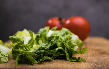 Fresh salad and tomatoes on a wooden board - studio photography