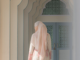 Rear view of Muslim woman in traditional clothing and hijab walking in the beautiful path.