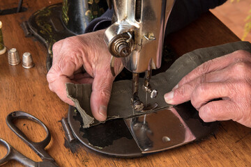 Man's hands behind sewing machine. Sew workshop. textile vintage sewing at home on wood table, sustainable sewing