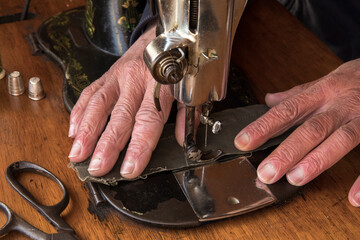 Male hands behind sewing machine. Sew workshop. textile vintage sewing at home on wood table, sustainable sewing