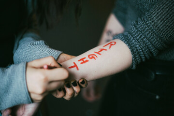 Cropped image of female protestor writing on woman's hand