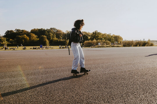 Young woman skating in park on sunny day