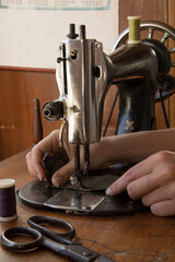 Woman's hands behind sewing machine. Sew workshop. textile vintage sewing at home on wood table, sustainable sewing
