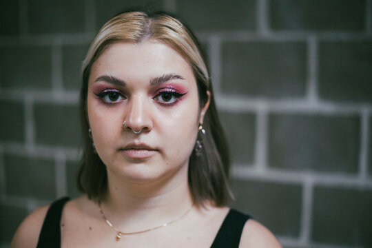 Portrait of young female protestor against wall