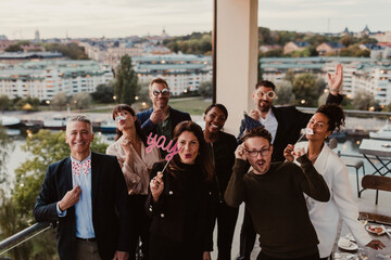 Portrait of smiling business people using props during company party