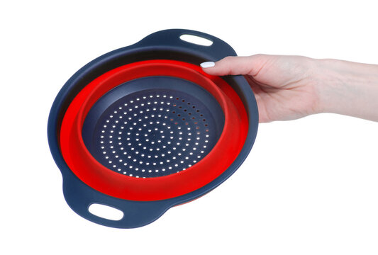 Collapsible silicone colander in hand on white background isolation