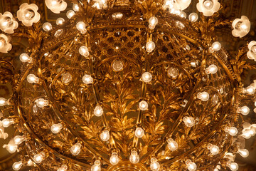 Different details of a luxurious theater with gold touches and stained glass