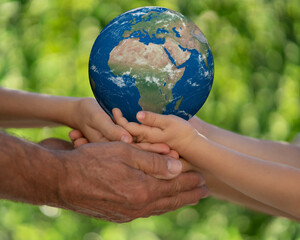 Family holding Earth planet in hands. Elements of this image furnished by NASA