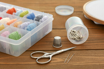 Accessories for embroidery are on a wooden table.