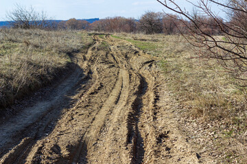 dirt road destroyed due to mud, traces from car wheels
