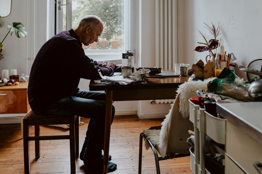 Emotionally stressed man at table in living room