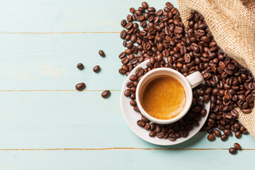 White cup of coffee and coffee bean on green background. Copy space,view from above