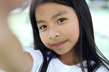 Beautiful Asia child girl smile selfie on walking street.