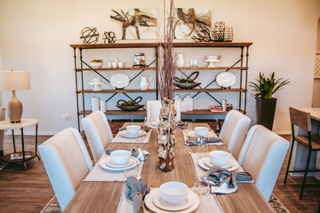 Kitchen interior design photos, place setting on the table. Light, bright modern homes living in luxury and style. Colors of white, blue, neutral - clean lines. Real estate photos.