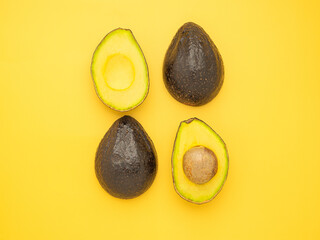 Top view of the fresh avocado half placed on a yellow background. Organic fruit. Space for text. Concept of healthy fruits and healthcare