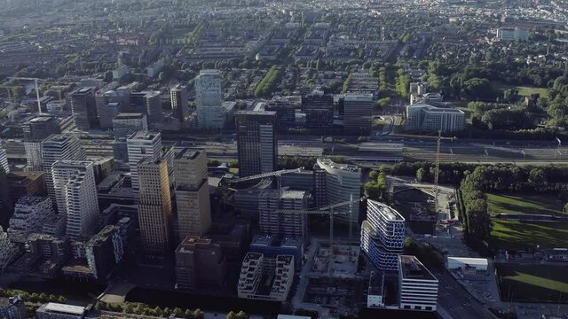 Aerial view of Amsterdam Financial Mile. The Zuidas in on a sunny day. Netherlands financial district with many buildings. It is located between the Amstel river and the A10 ringway.

