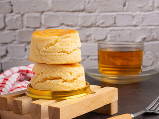 Close-up of style English scones delicious freshly baked homemade and a teacup with white brick wall background. Side view. Dessert and beverage concept