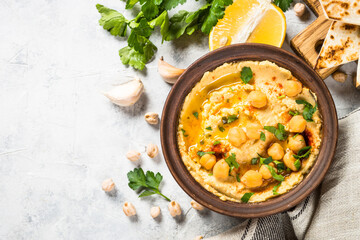 Hummus with olive oil and paprika at light kitchen table.