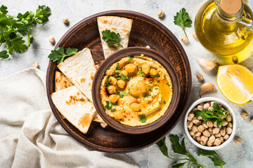 Hummus with olive oil and paprika at light kitchen table.