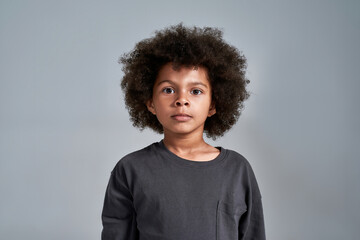 Cute little african american kid on light background