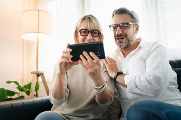 Happy couple elderly retirement using mobile phone to video conference call with family in the living room atmosphere, Social distancing family during coronavirus pandemic.