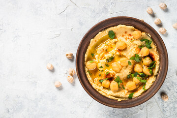 Hummus with olive oil and paprika at light kitchen table.