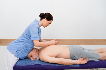mature man lying on massage table during massotherapy