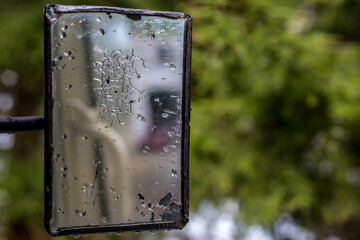 Misted rectangular train mirror with reflection. The mirror on the background of green forest.