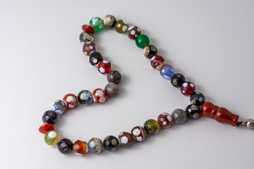 Colorful men's Muslim Prayer beads heart shape on white background 