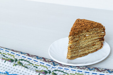 Piece of honey cake close-up on a light background.