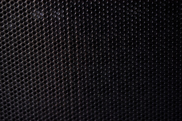 Black background made of iron grating with small round holes