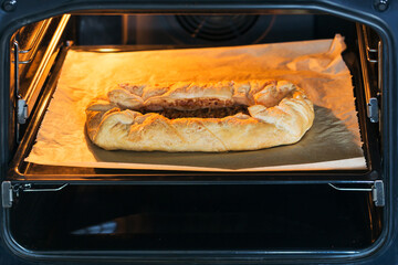 Homemade apple pie baking in oven at the kitchen