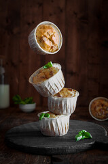 Flying cupcakes for snacks, on a dark wooden background with basil