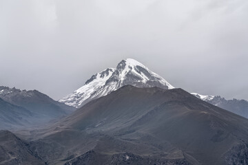 Snow-capped Mount Kazbeg against the background of a cloudy sky