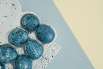 Minimalistic easter mockup. Stylish Easter eggs in blue tones of the night sky on a pastel yellow-blue background. Easter composition. Space for text, top view, flat lay