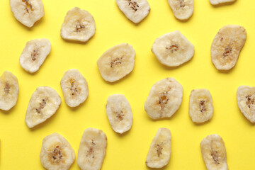 Композиция с кусочками сладкого сушеного банана на желтом фоне. Сухофрукты как полезная закуска