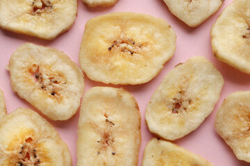 Composition with sweet dried banana slices on a pink background. Dried fruit as healthy snack