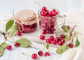 Cherry jam with fresh cherries on a white background.