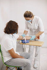Nurse taking blood sample from patient at the doctors office